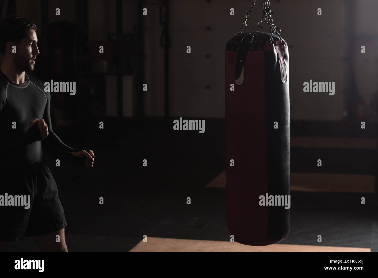 Boxer practicing boxing with punching bag Stock Photo Alamy