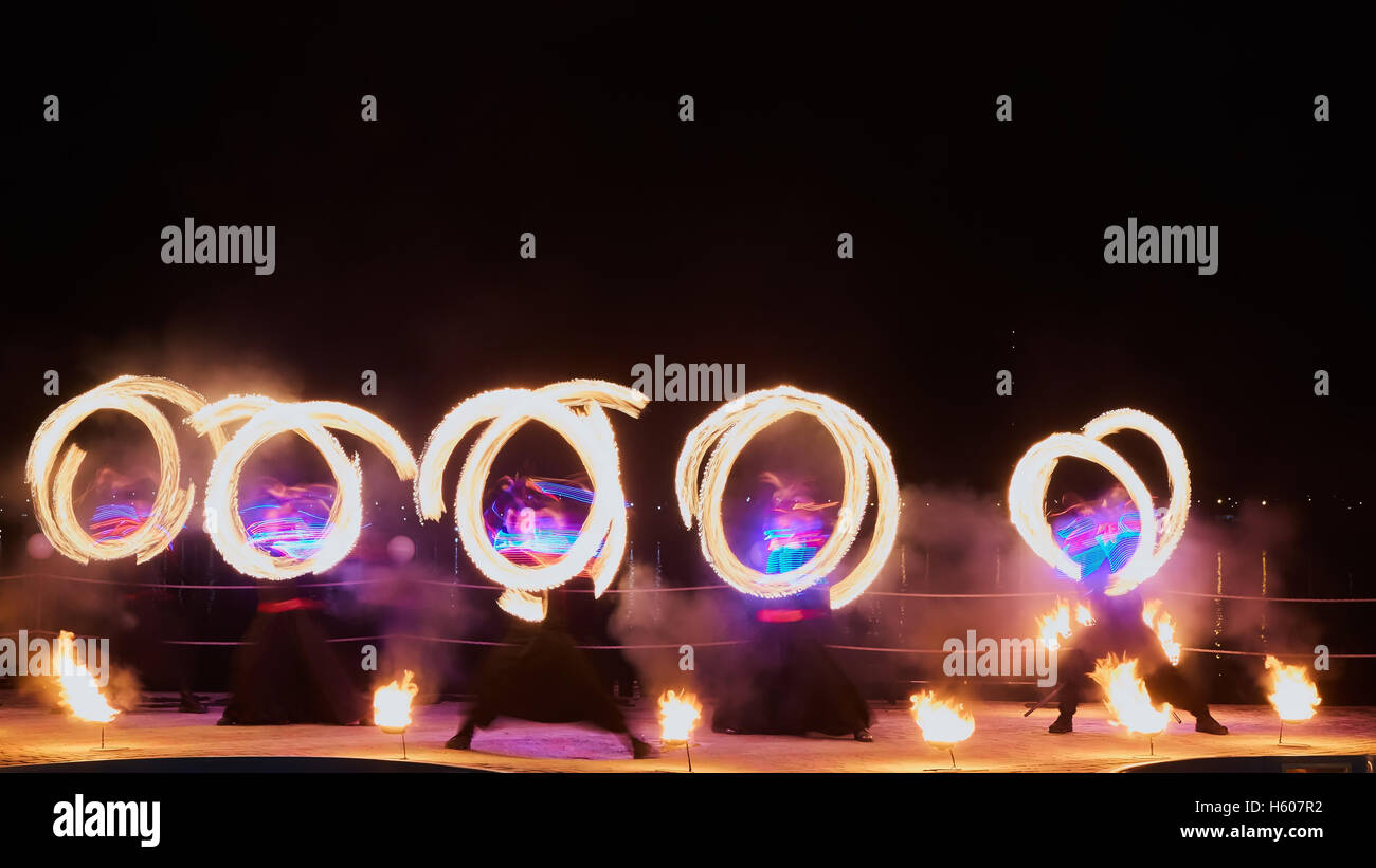 Artists juggling with burning poi's at fire performance. Long exposure