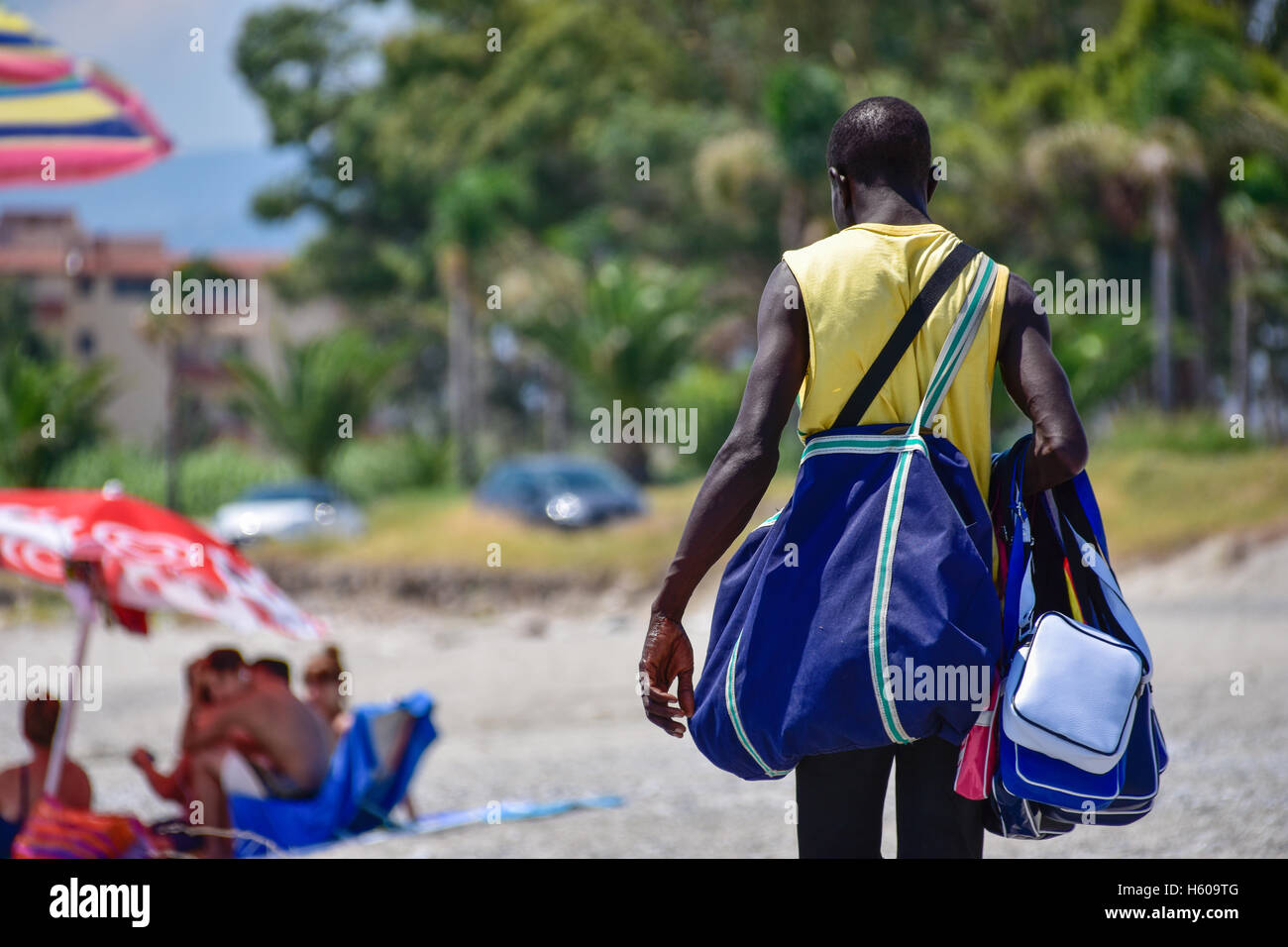 African vendor trying to sell to tourists on the beach. Stock Photo