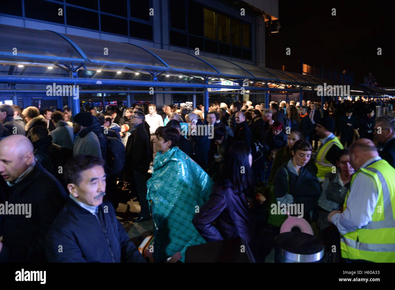 Poeple outside London City Airport which has been closed as dozens of passengers were treated for breathing difficulties after a suspected chemical incident at the airport. Stock Photo