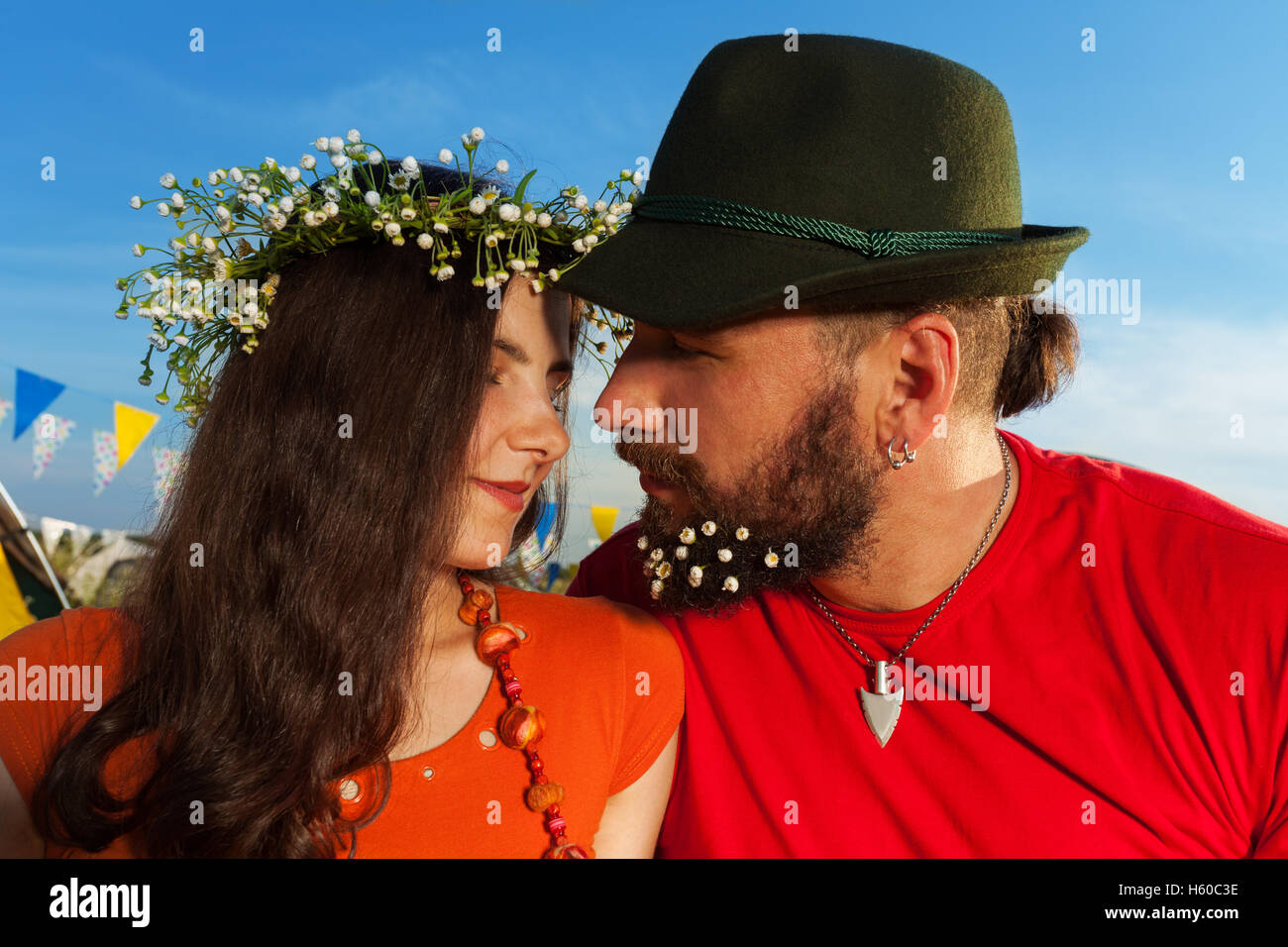 Portrait of young couple kissing against blue sky Stock Photo