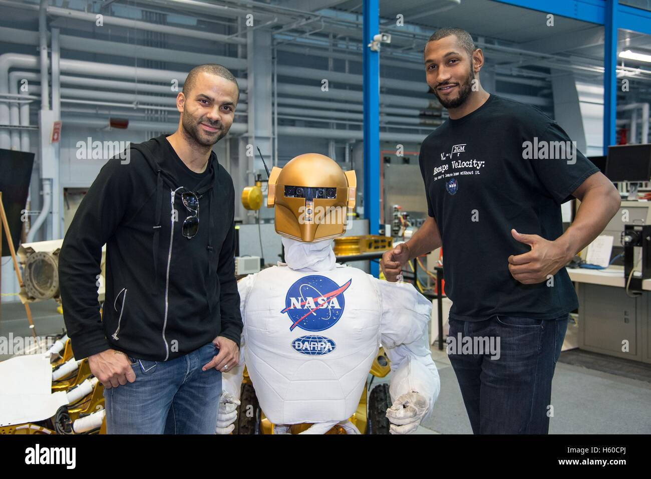 French professional basketball players Tony Parker (left) and Boris Diaw of the San Antonio Spurs pose with the NASA Valkyrie R5 Robot at the Johnson Space Center Dexterous Robotics Laboratory during a tour led by French astronaut Thomas Pesquet of the European Space Agency April 2, 2015 in Houston, Texas. Stock Photo