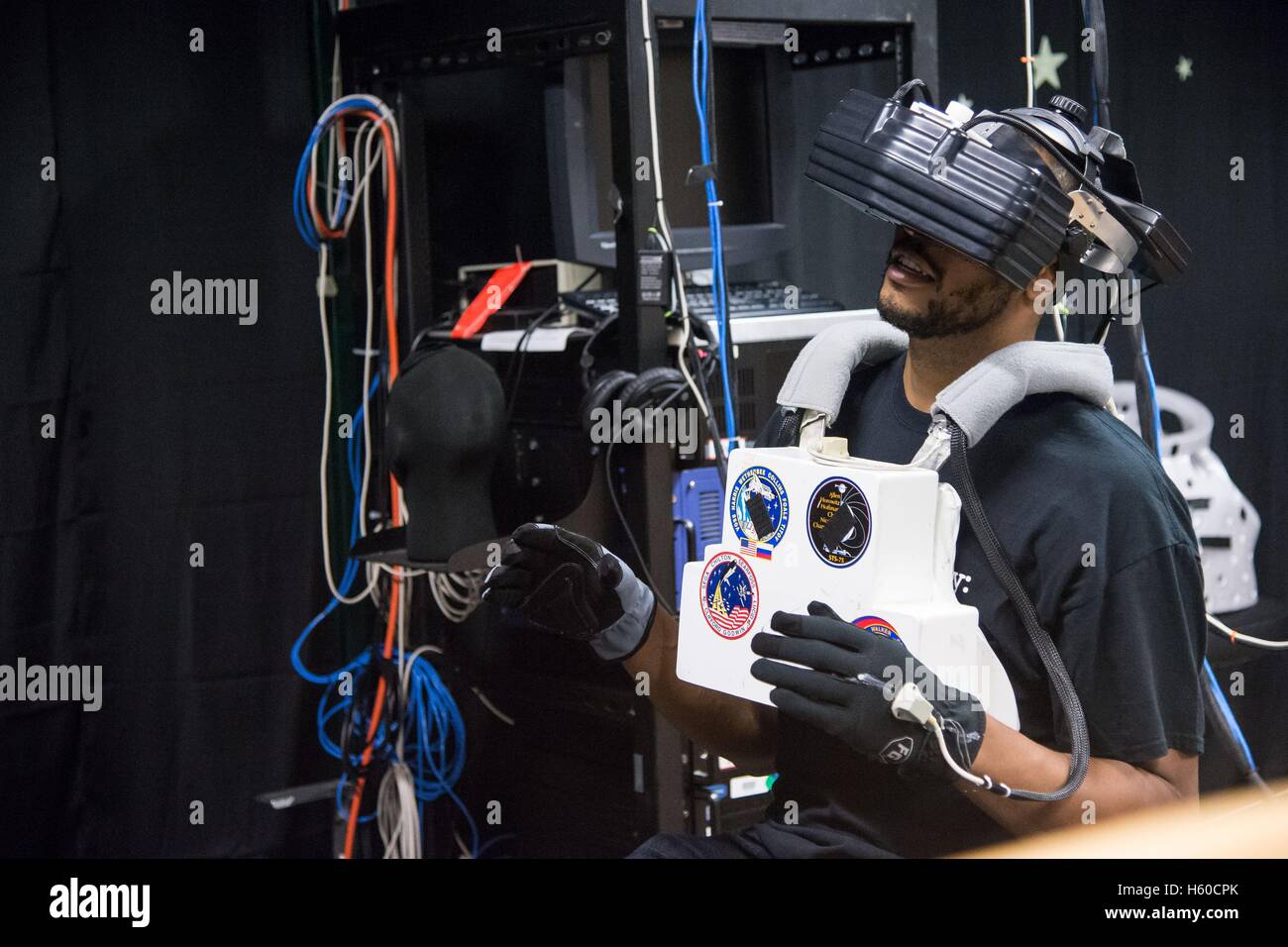 French professional basketball player Tony Parker of the San Antonio Spurs samples virtual reality hardware that simulates an EVA spacewalk at the Johnson Space Center Space Vehicle Mockup Facility Virtual Reality Laboratory during a tour led by French astronaut Thomas Pesquet of the European Space Agency April 2, 2015 in Houston, Texas. Stock Photo