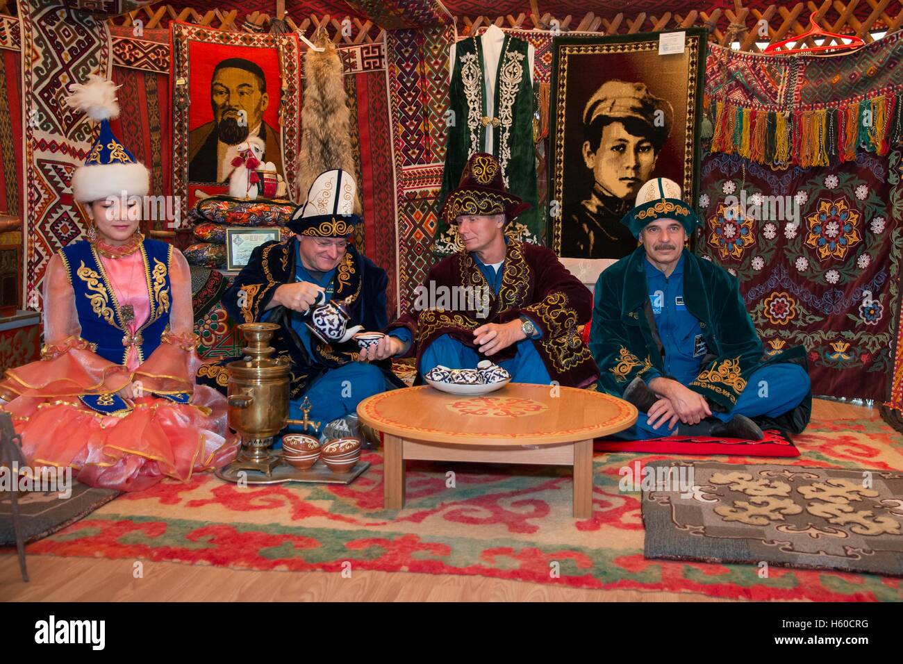 NASA International Space Station Expedition 41/42 mission backup crew members (L-R) American astronaut Scott Kelly, and Russian cosmonauts Gennady Padalka and Mikhail Kornienko of Roscosmos eat a traditional Kazakh lunch in a yurt during a tour of Baikonur September 14, 2014 in Baikonur, Kazakhstan. Stock Photo