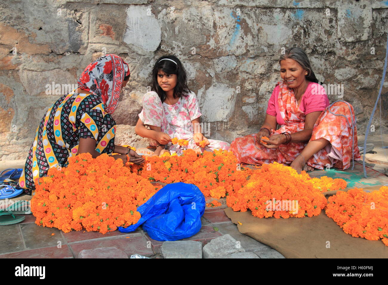 Preparing Marigold garlands for Diwali, the Hindu Festival of Lights, Delhi, India, Indian subcontinent, South Asia Stock Photo