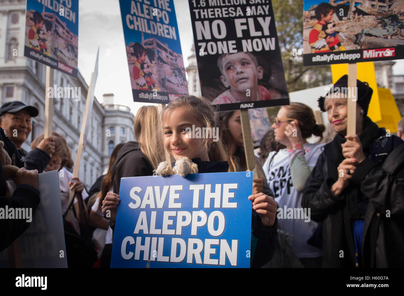 Children join demonstrators outside the gates of Downing Street in central London during a protest to highlight the high numbers of children killed in bombings in Syria and to demand the Government intervene over Russian and Syrian bombing campaigns. Stock Photo