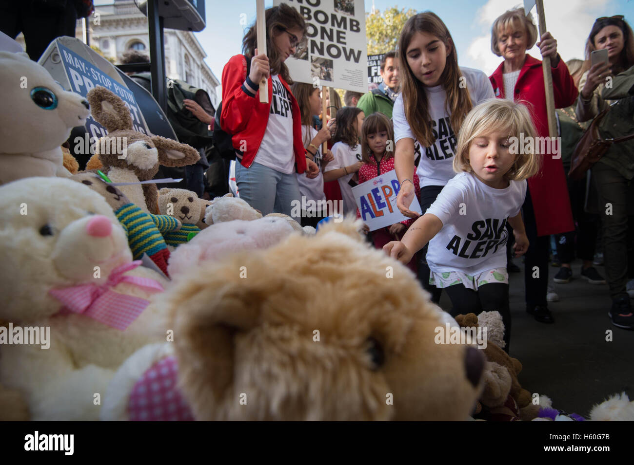 Children join demonstrators in laying teddy bears outside the gates of Downing Street in central London during a protest to highlight the high numbers of children killed in bombings in Syria and to demand the Government intervene over Russian and Syrian bombing campaigns. Stock Photo