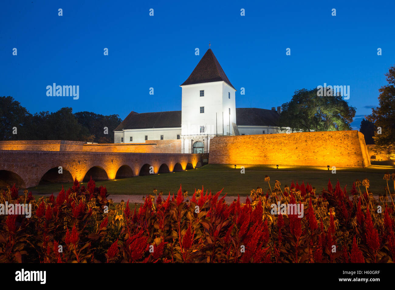 Evening view of the fortress in Sarvar. Beautiful color appearance. The illuminated castle, Plants and Trees. Stock Photo