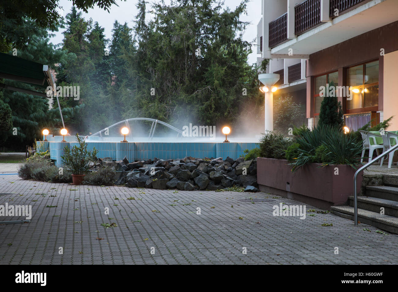 Outdoor pool with thermal water spa near the hotel. Water smokes over the pool. Thermal complex. Stock Photo