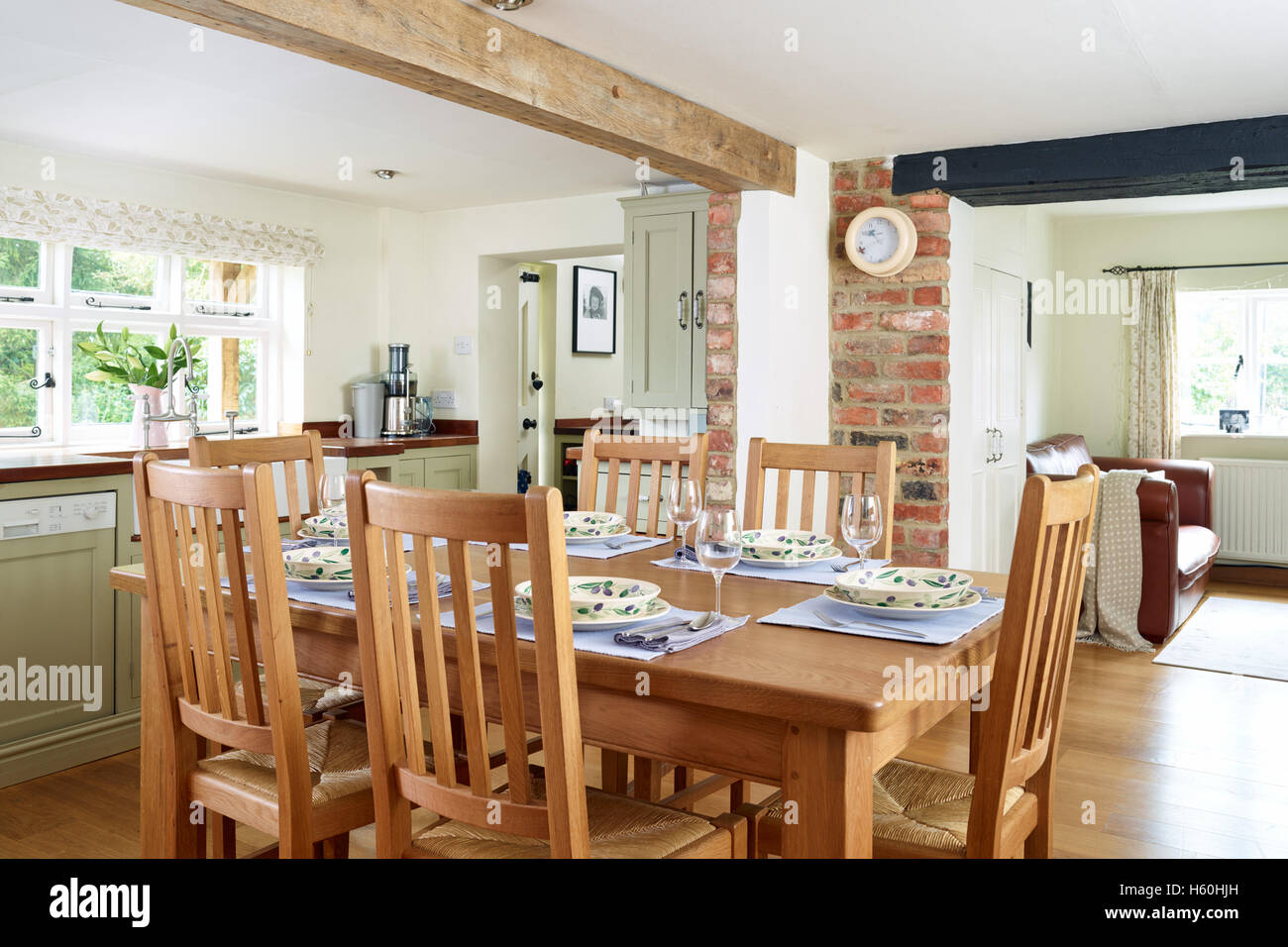 A country kitchen, dining area with a table dressed for dinner Stock Photo