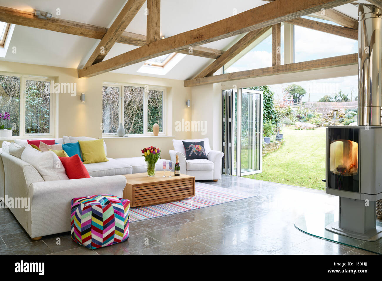 A fresh, modern extension, garden room with wood burner & view of the garden through bi-fold doors Stock Photo