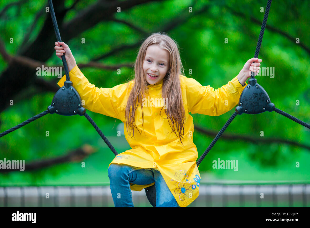 Happy little girl playng on outdoor playground Stock Photo - Alamy