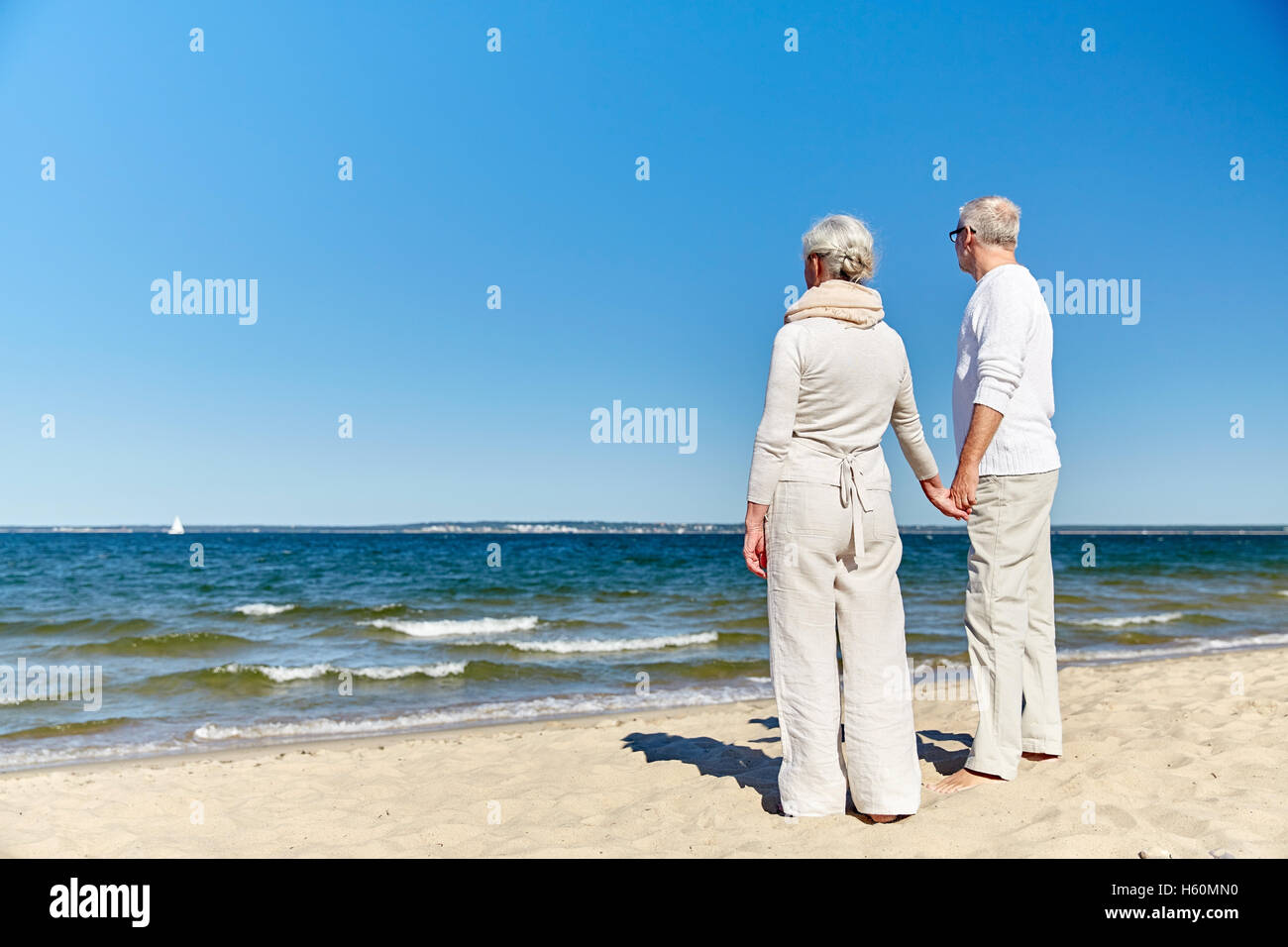 happy senior couple holding hands summer beach Stock Photo - Alamy