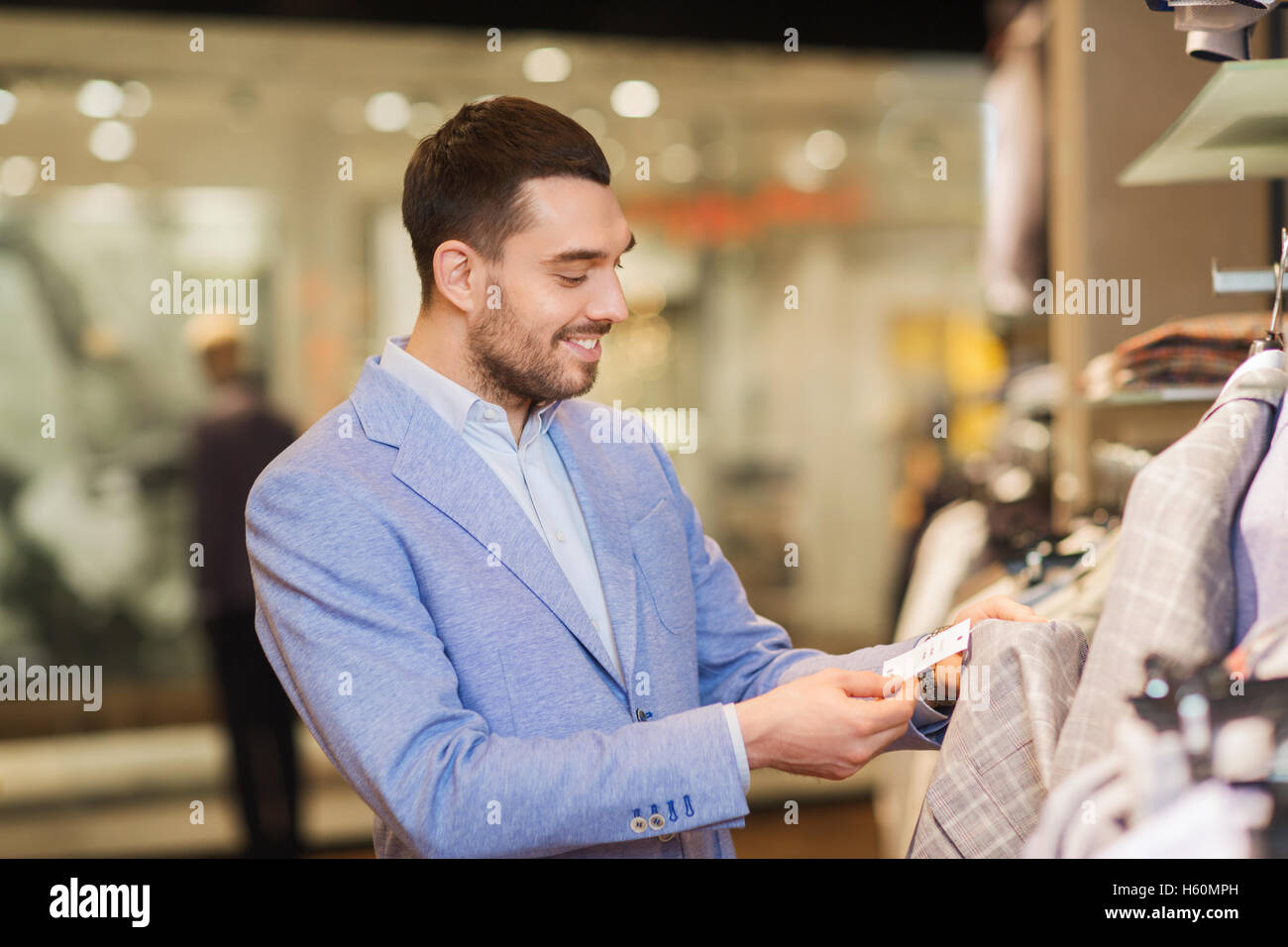 happy young man choosing clothes in clothing store Stock Photo - Alamy