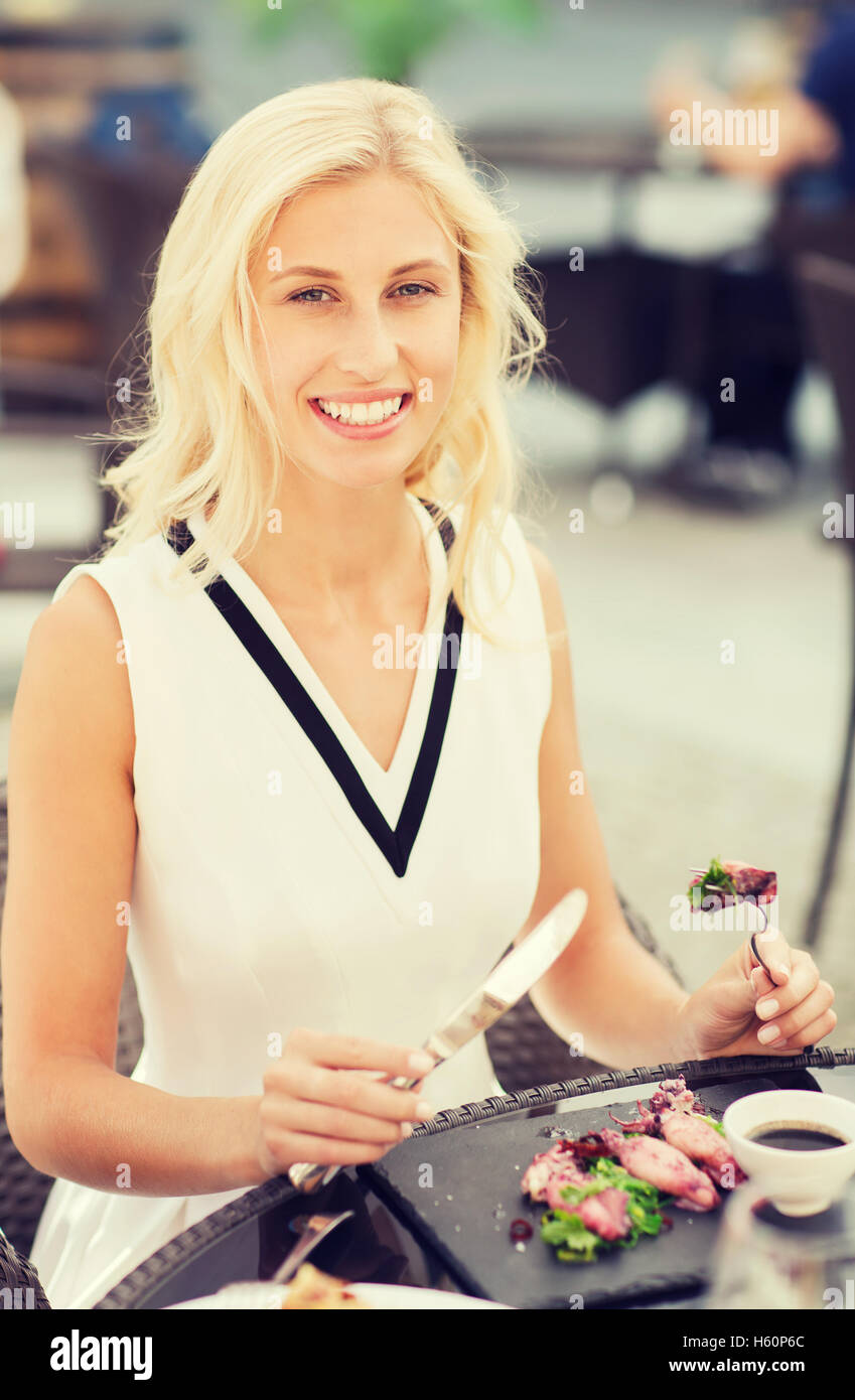 happy woman eating dinner at restaurant terrace Stock Photo - Alamy