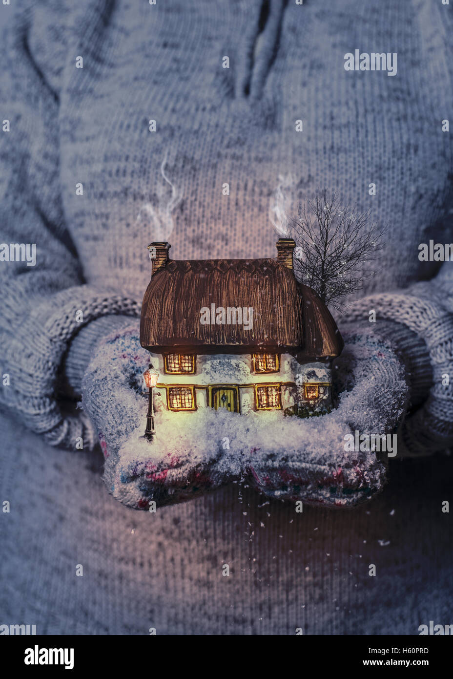 Winter cottage scene in gloved hands Stock Photo