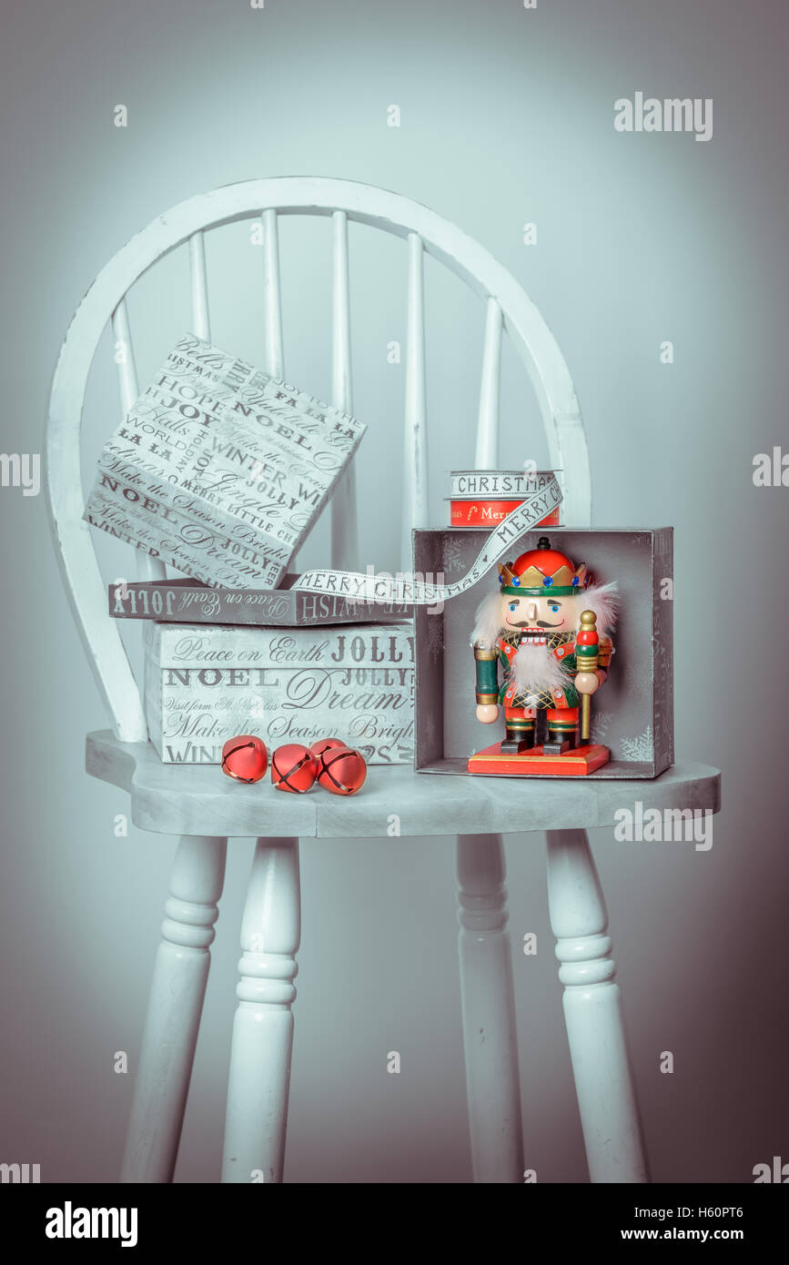 Vintage nutcracker sitting on chair with Christmas presents Stock Photo
