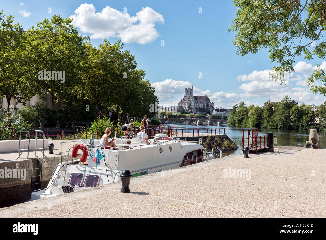 Holidaymakers on a riverboat negotiating a lock on the river Yonne in Auxerre, Burgundy, France Stock Photo