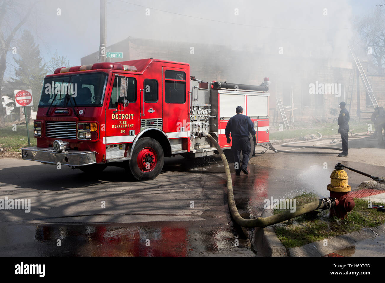 Fire engine pumper hooked to fire hydrant at house fire, Detroit, Michigan USA Stock Photo