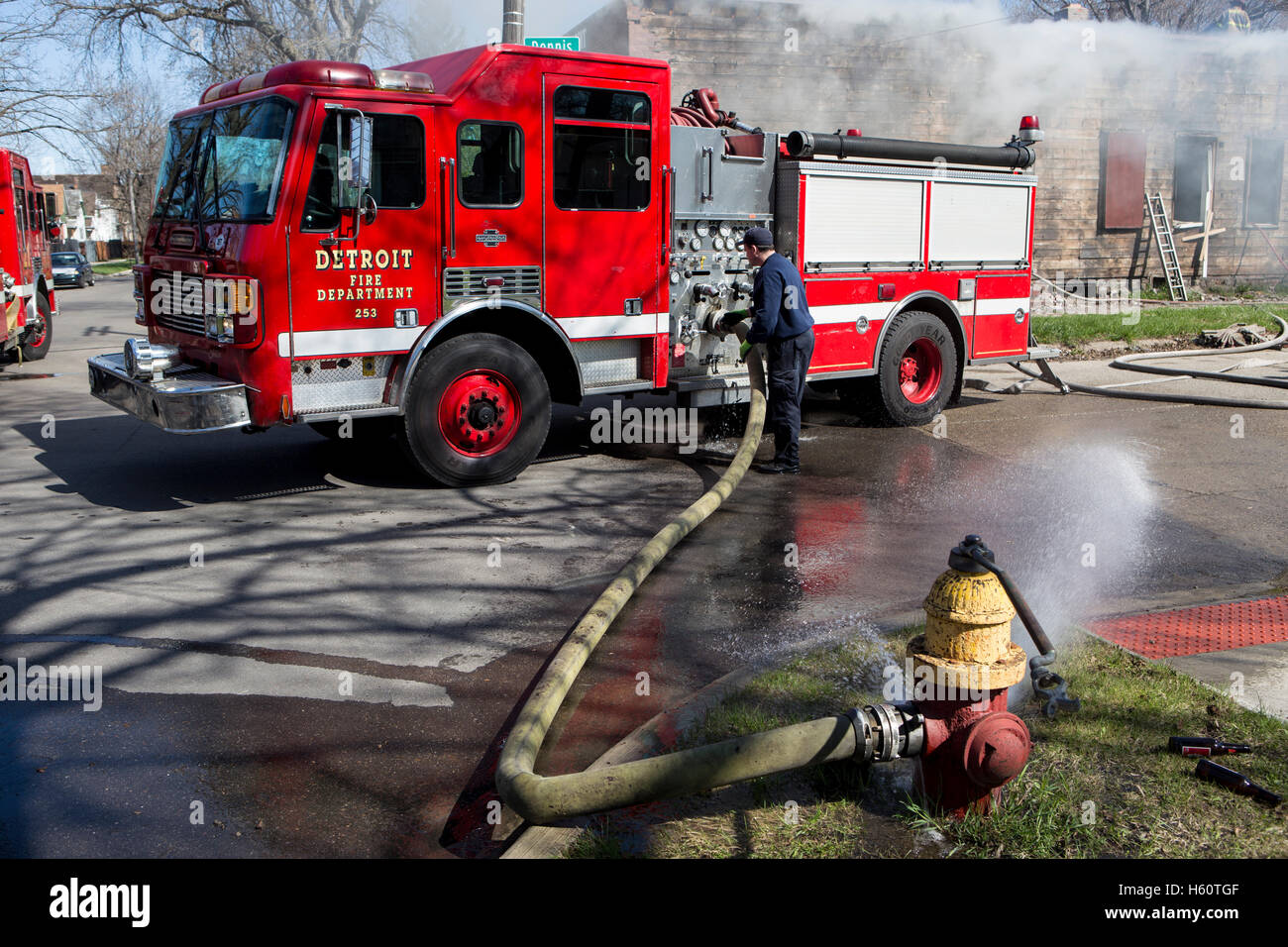 Fire engine pumper hooked to fire hydrant at house fire, Detroit, Michigan USA Stock Photo
