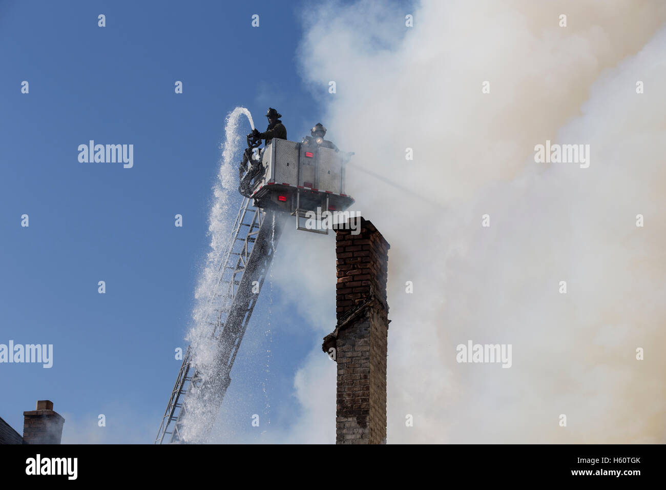 Aerial Tower Ladder extinguishing house fire, Detroit, Michigan USA Stock Photo
