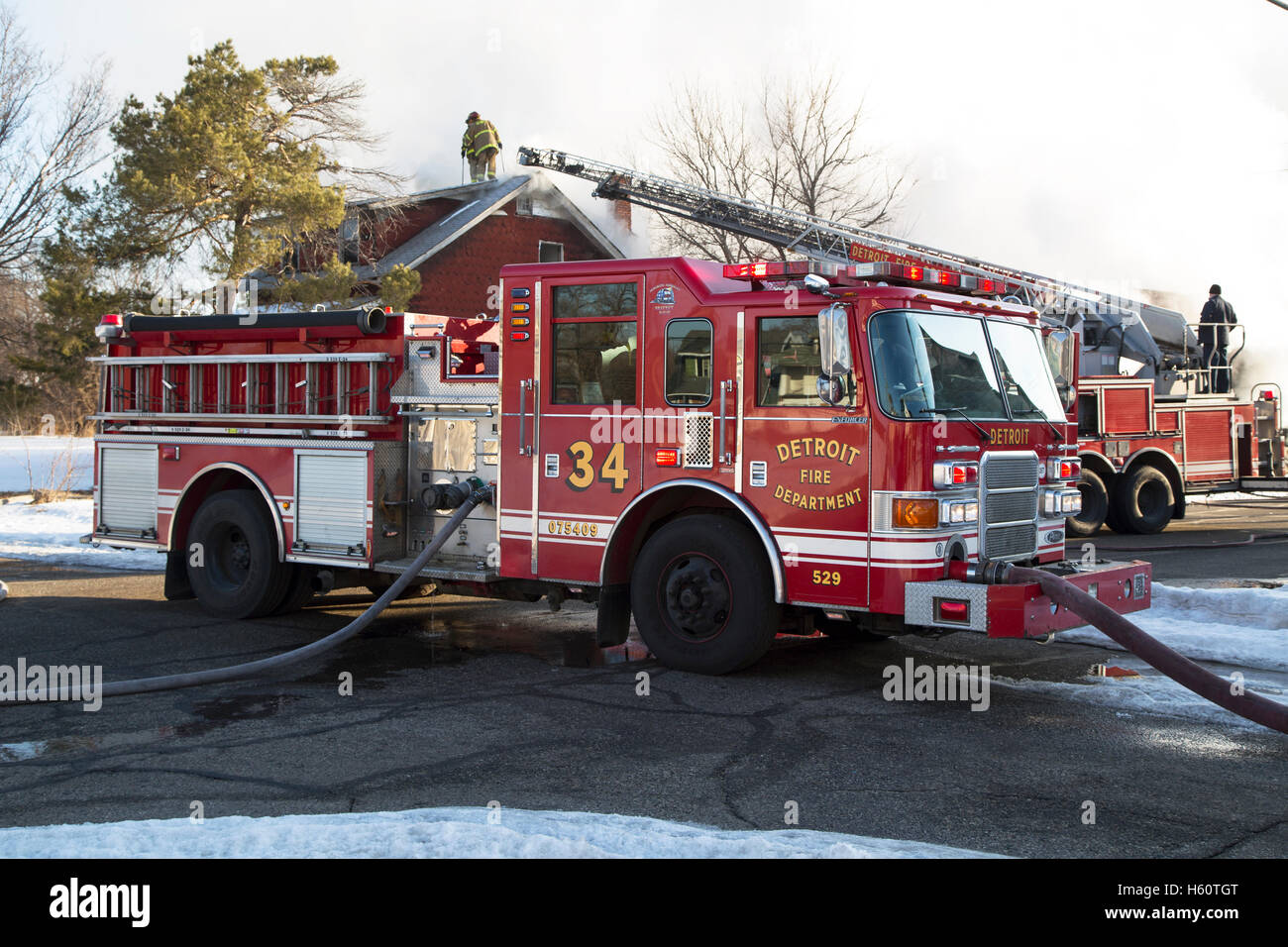 Aerial truck, Engine company, and firefighters extinguishing house fire
