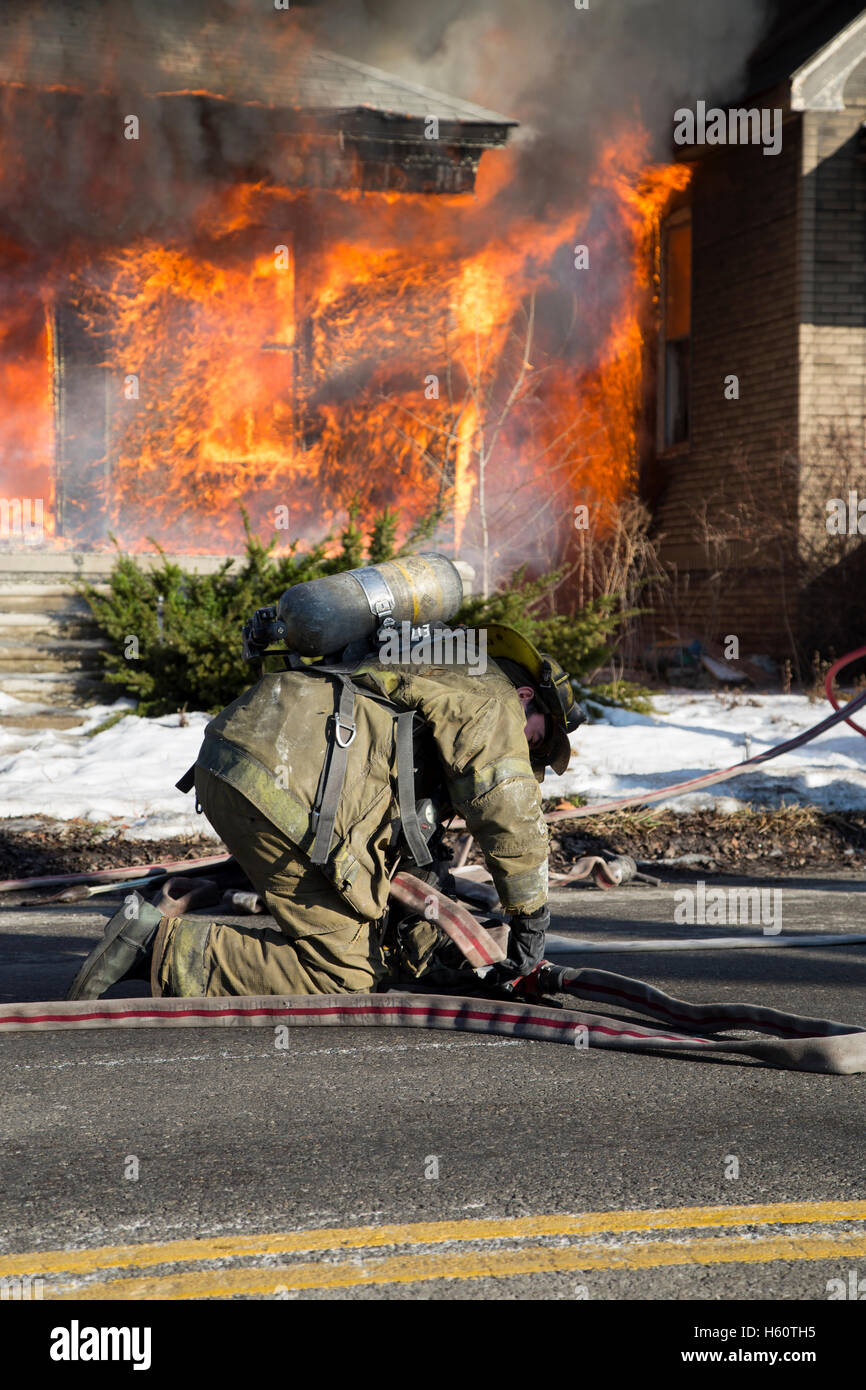 Firefighter preparing hoses, house fire, Detroit, Michigan USA Stock Photo