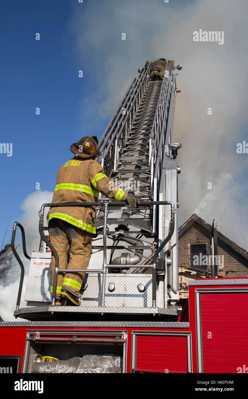 Firefighter operating Aerial ladder at scene of house fire, Detroit, Michigan USA Stock Photo