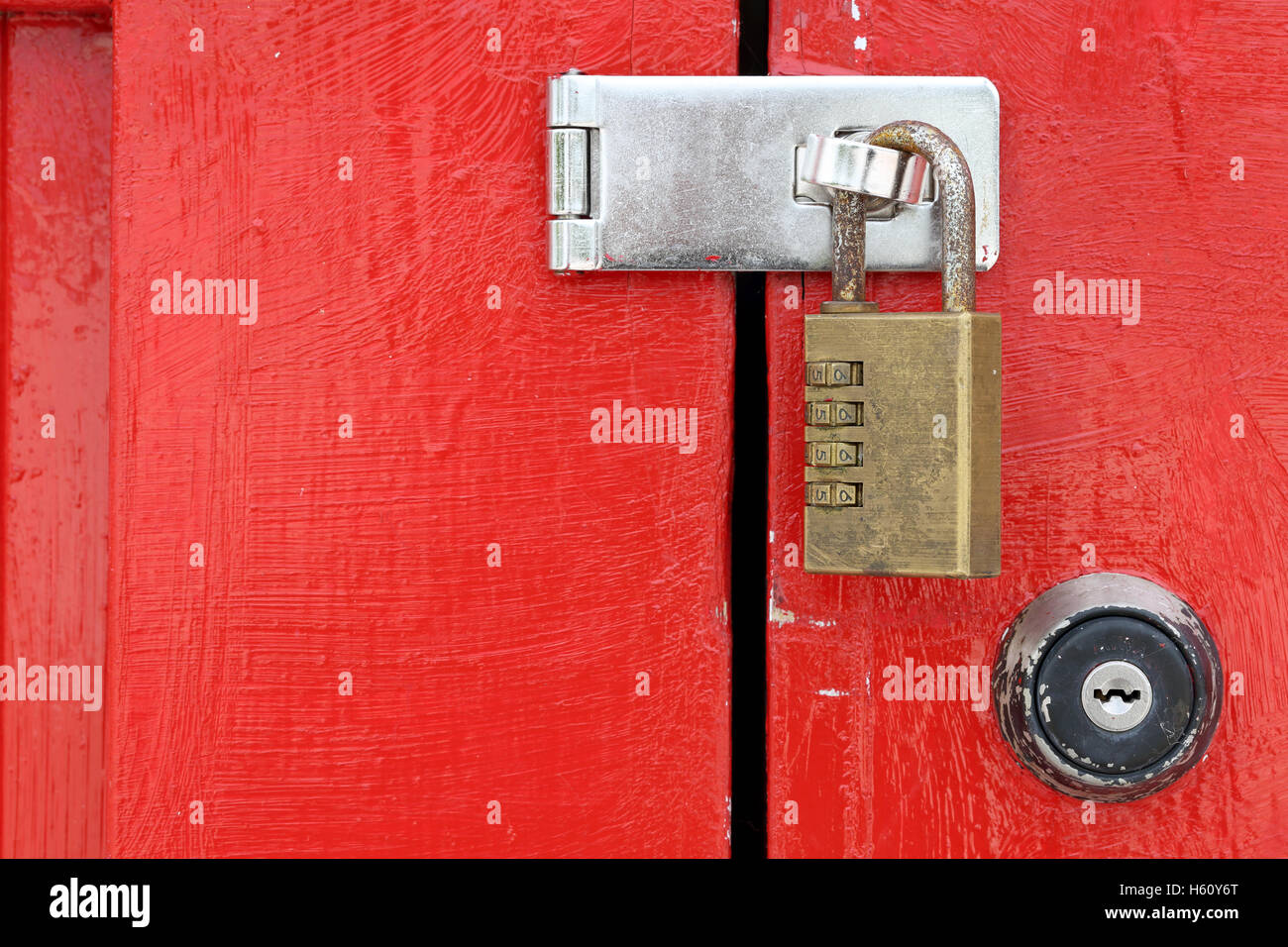 closed old wooden red door with padlock Stock Photo