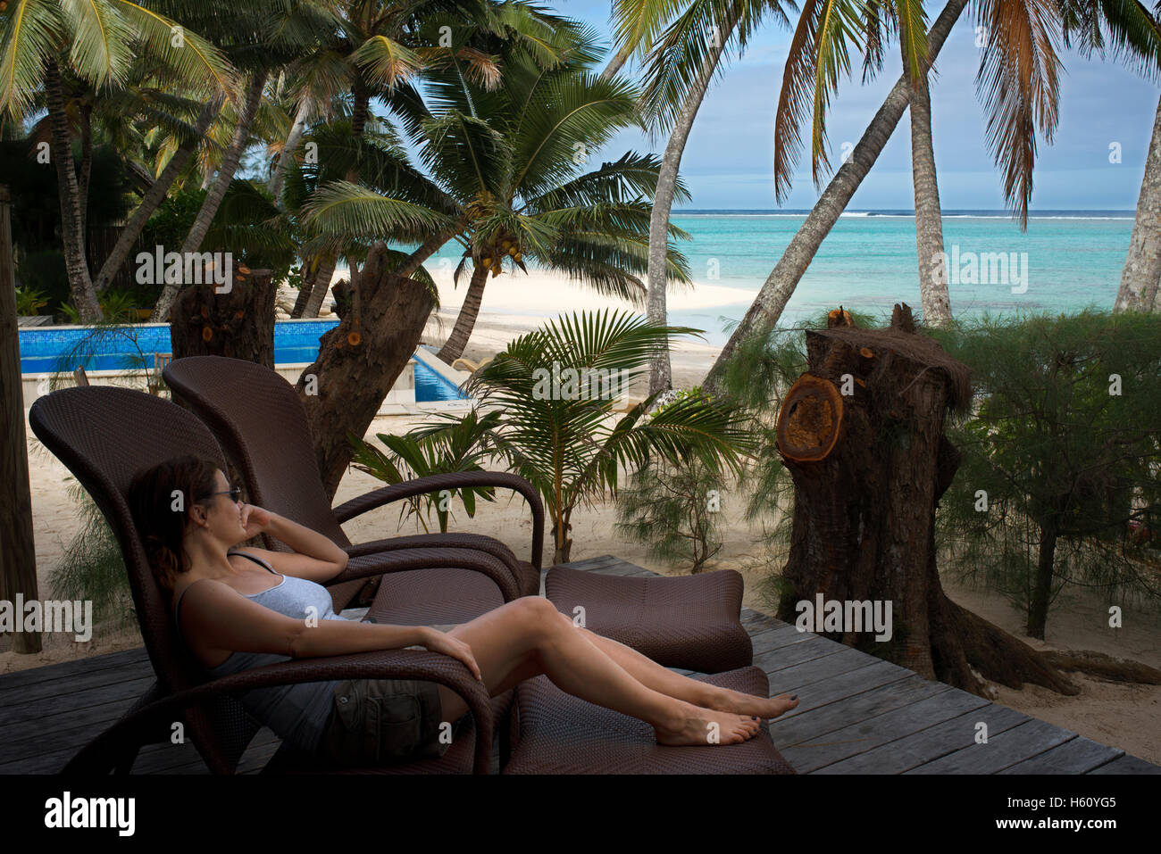 Rarotonga Island. Cook Island. Polynesia. South Pacific Ocean. A woman client relaxing on a deck chair by the sea in the luxurio Stock Photo