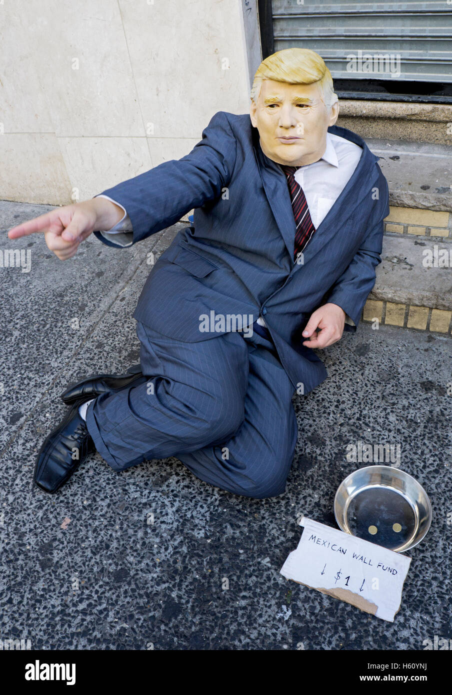 Man in a Donald Trump mask and suit allegedly collecting money to build a Mexican wall at the border. In downtown New York City Stock Photo