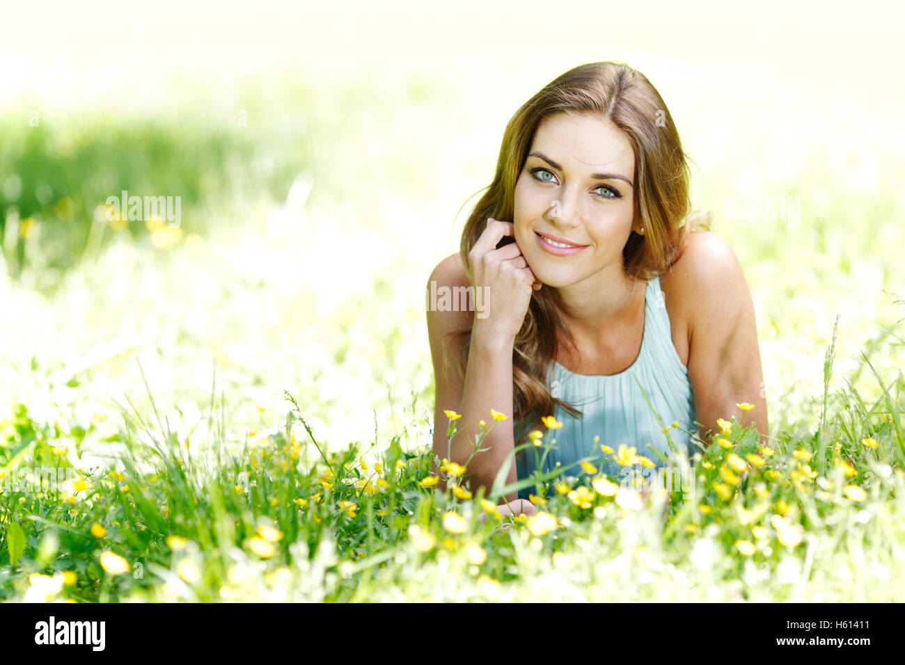 beautiful young woman in blue dress lying on grass Stock Photo - Alamy