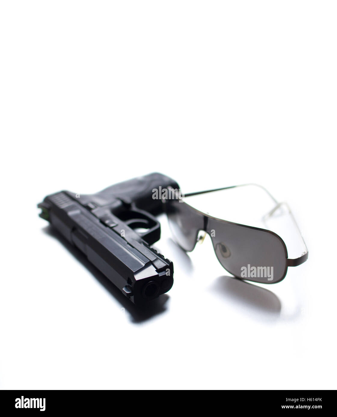 Handgun and Sunglasses on White Background Stock Photo