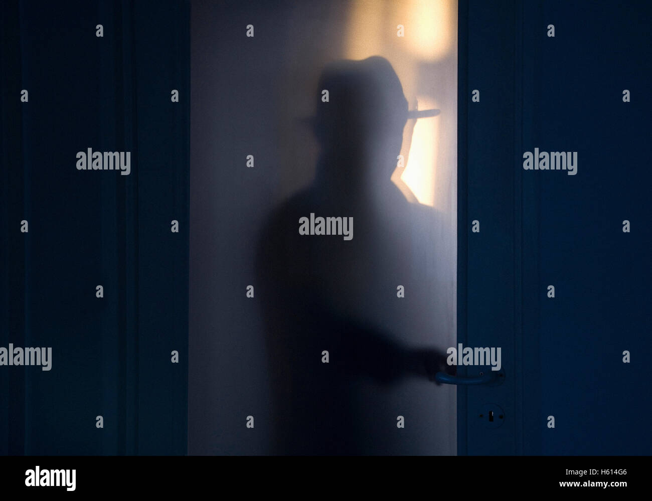 Silhouette of Mysterious Man Opening Door Stock Photo