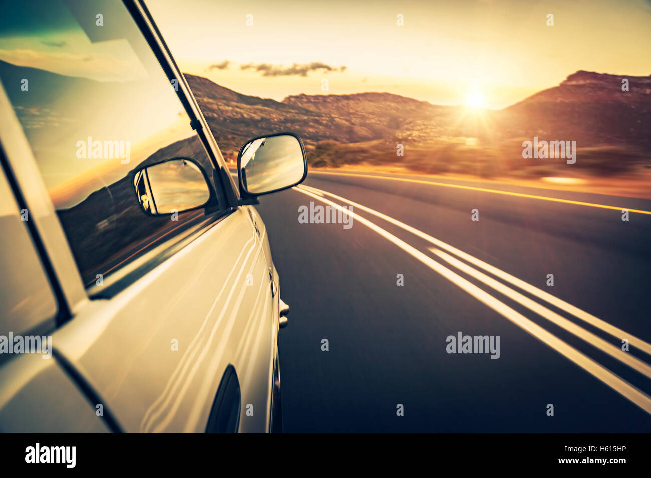 Road trip on sunset, car on the highway, conceptual image of escape and adventure travel, slow motion photo Stock Photo