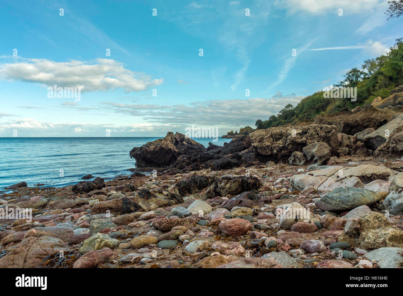 Seascape depicting the rocky, pebbled shoreline at Ansteys Cove, Redgate Beach and Lyme Bay on a beautiful summers day, near Torquay, Devon Stock Photo