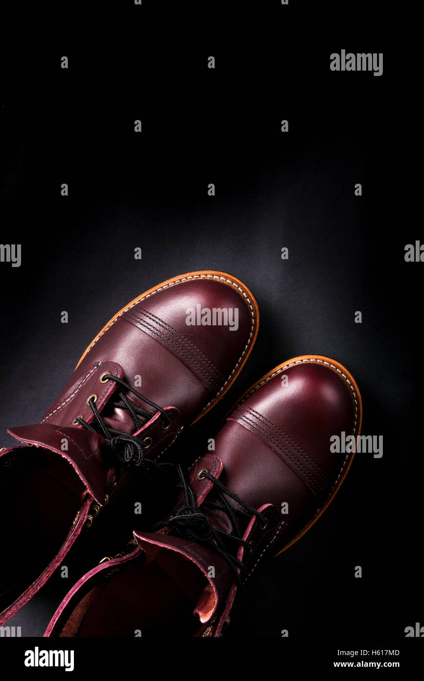 Fashionable mens leather brown shoes on black background. . Men's high boots. Top view. Stock Photo