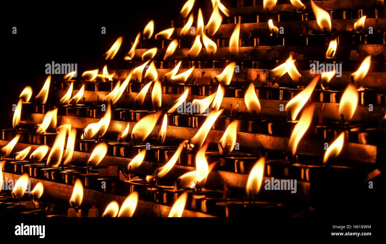 Prayer, offering, sacrificial or memorial candles with bokeh effect in