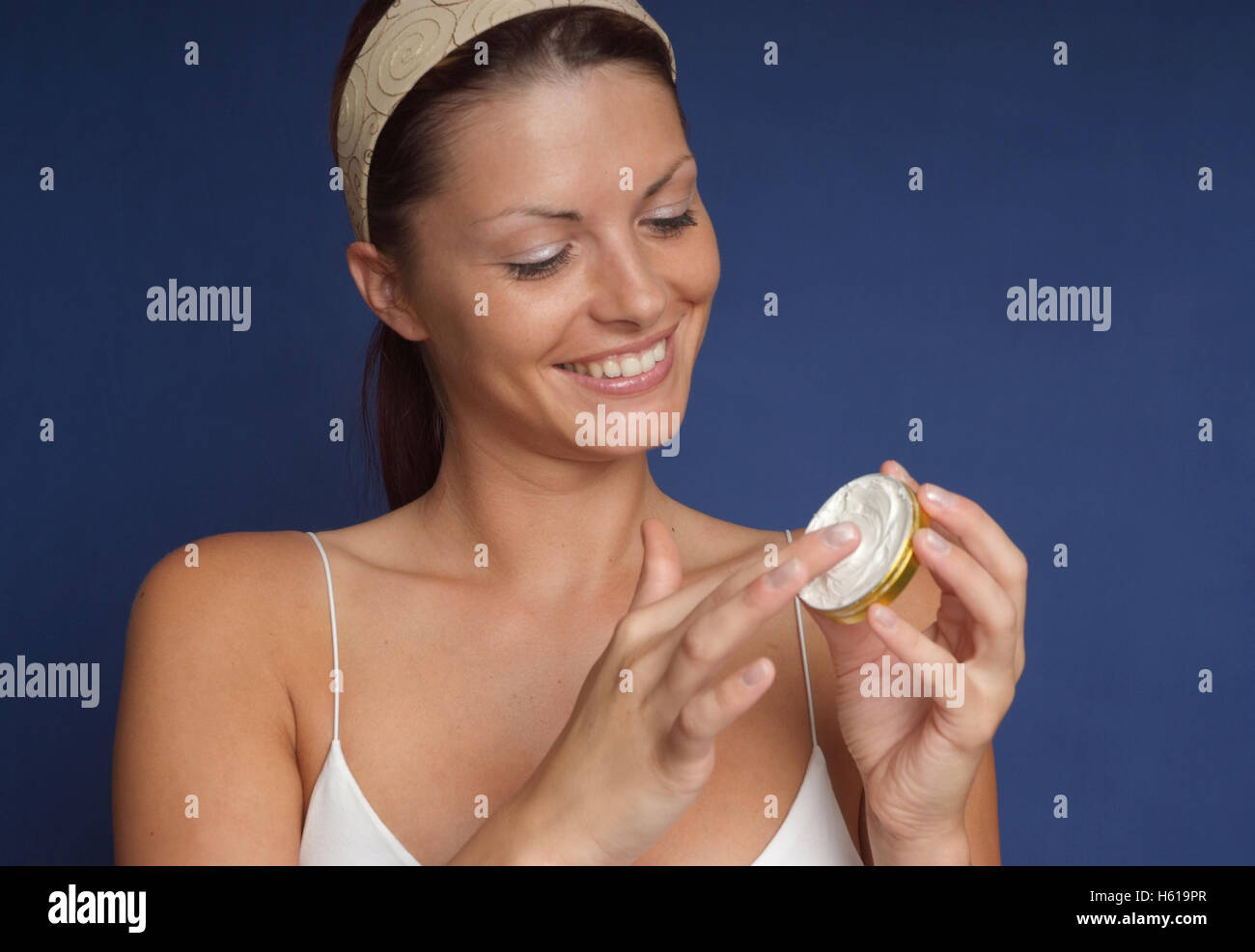 Woman using face cream Stock Photo Alamy