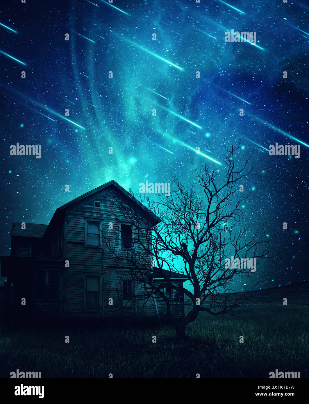 A ghost, haunted house and a scary tree in the meadow below a cold dark blue sky. Spooky landscape with a starry night sky backg Stock Photo