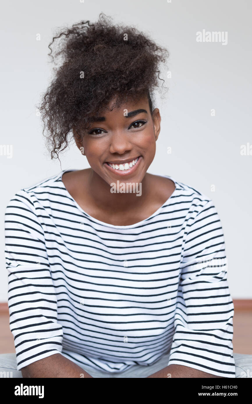 Portrait of a woman sitting on floor at home Stock Photo - Alamy