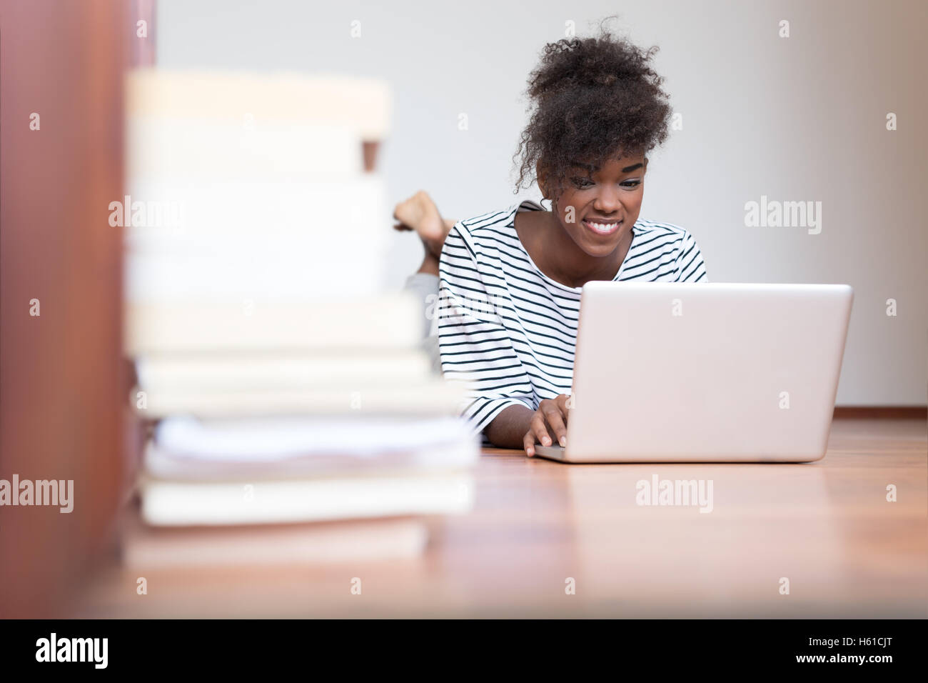 Black African American teenage girl lying down on the wood floor Stock ...