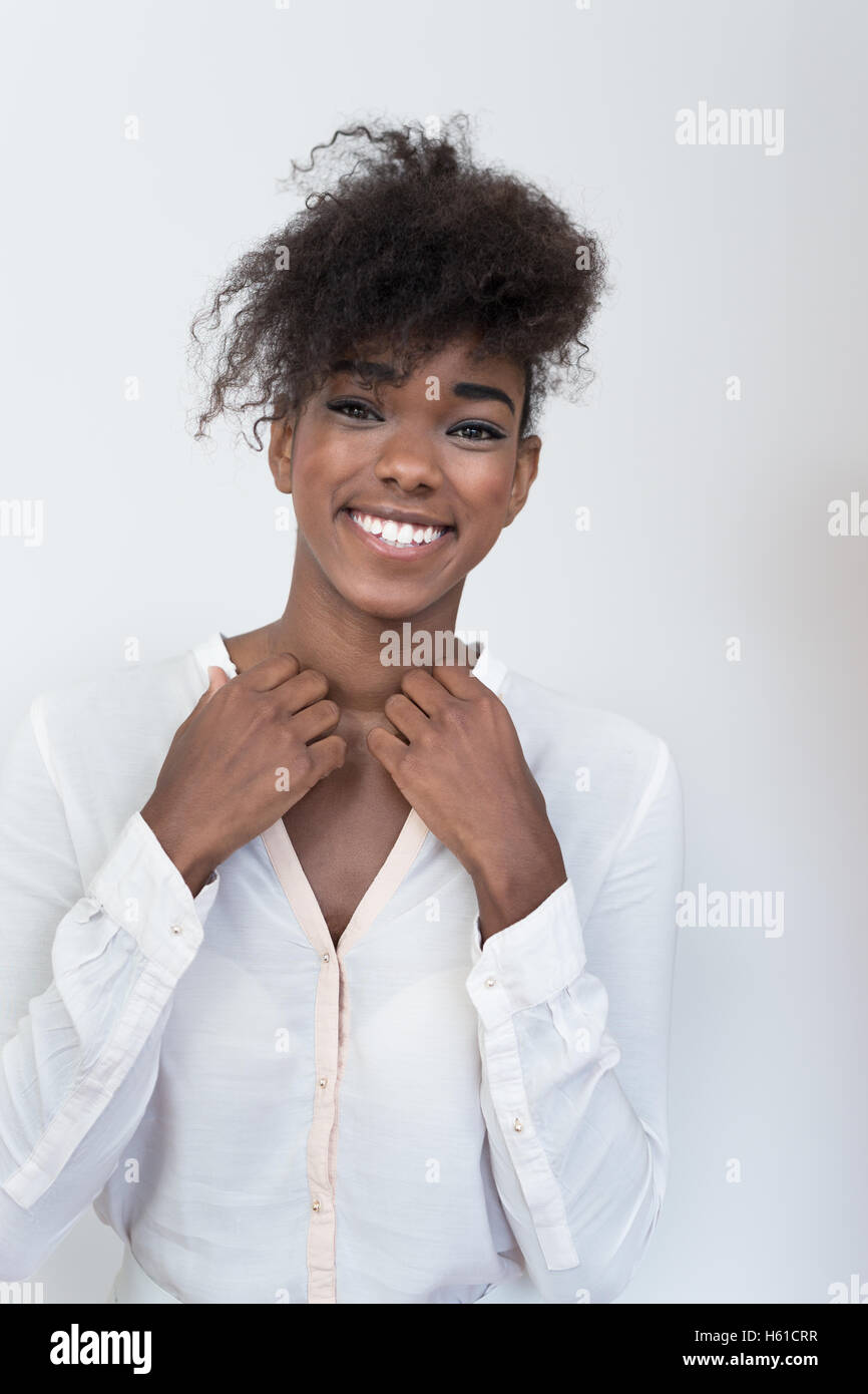 Portrait of happy young afro american woman smiling against white wall ...