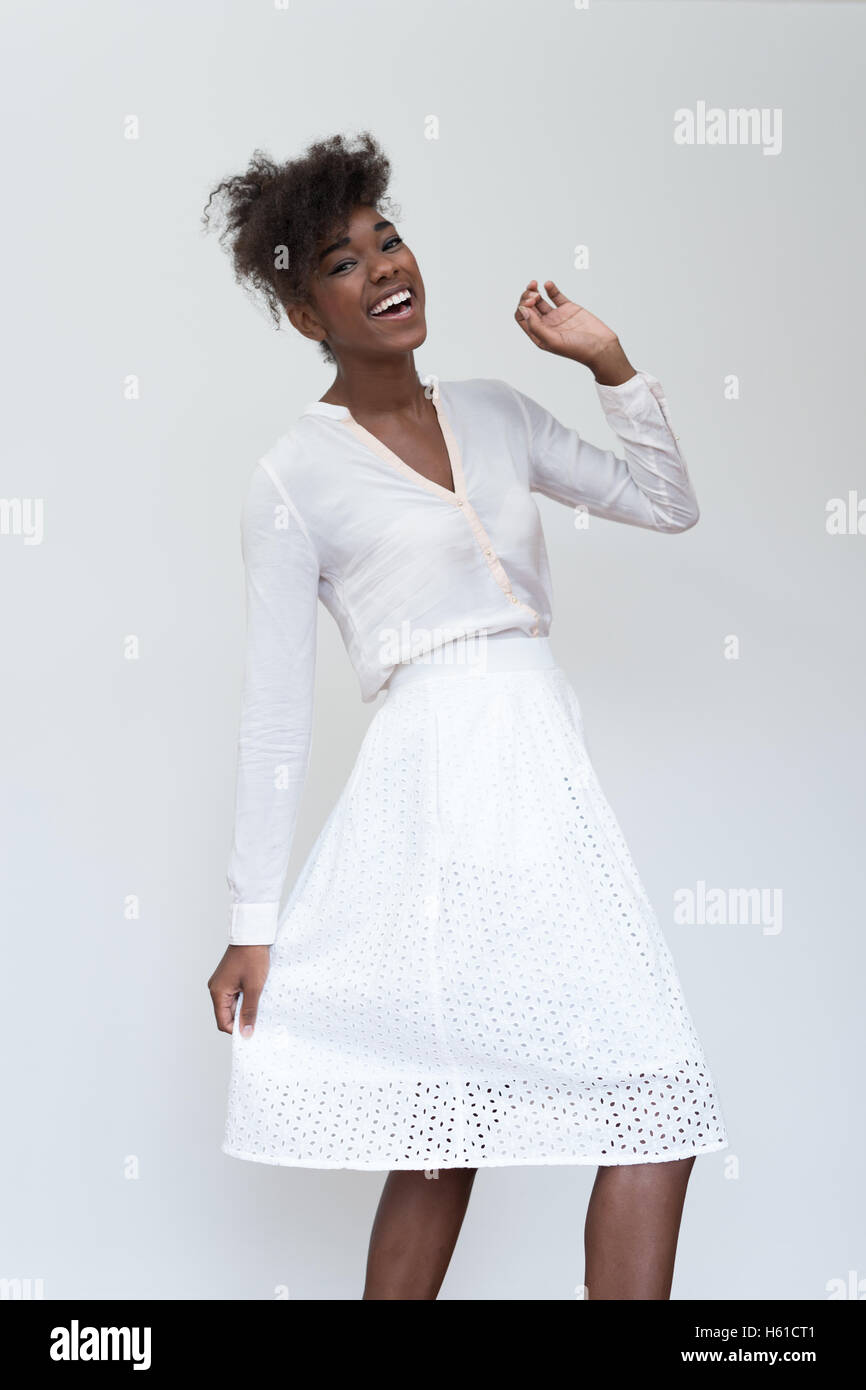 Close up portrait of young black woman laughing against white ...