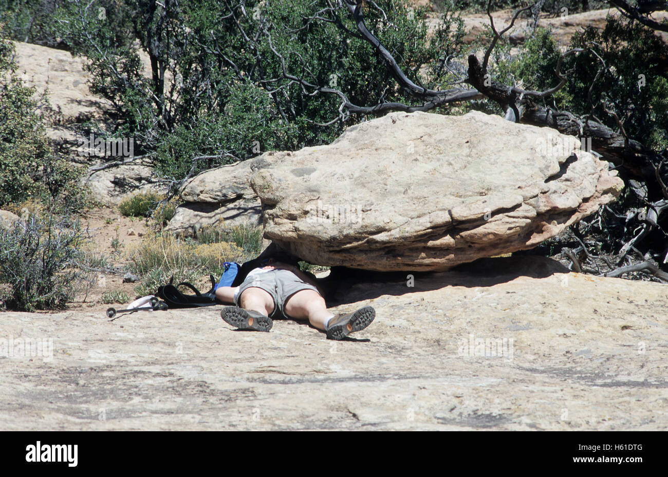 Exhausted hiker seeks shade and rest in Canyon de Chelly National Monument, Arizona Stock Photo