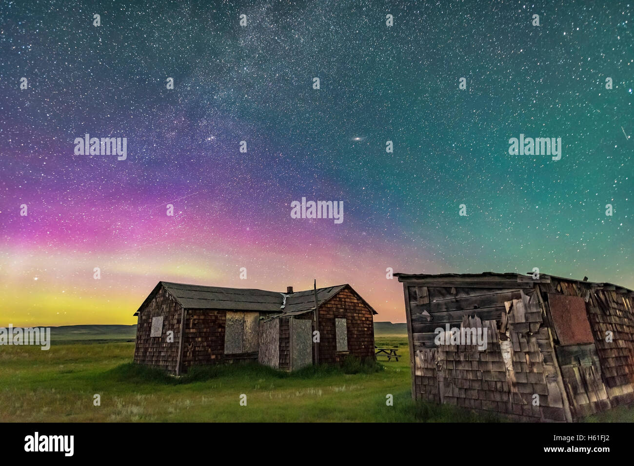 A dim aurora to the north at Grasslands National Park, Saskatchewan, at the Larson Ranch site and its rustic pioneer cabins. Tak Stock Photo