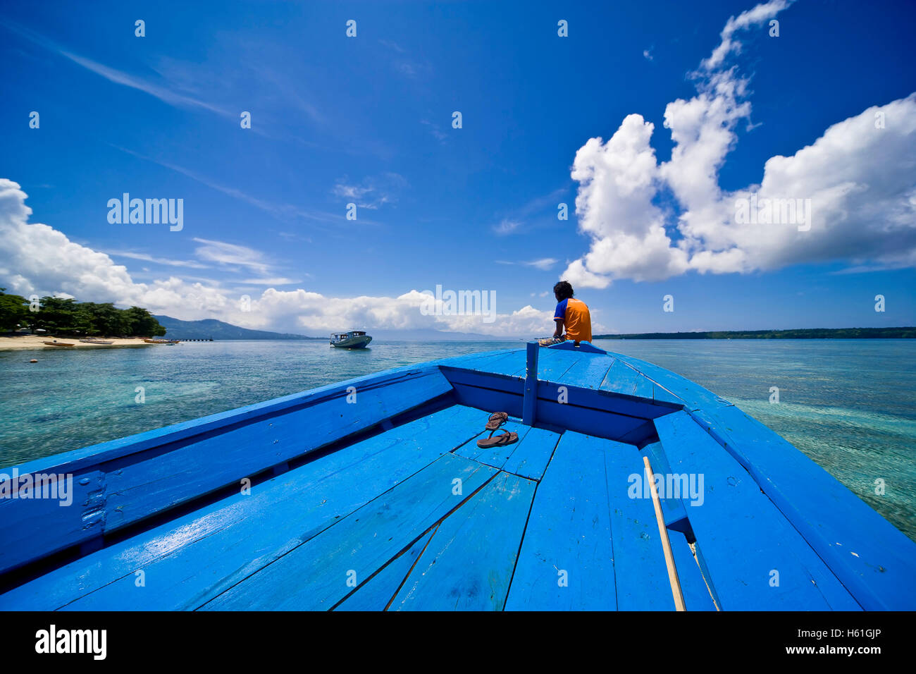 Young woman sitting at the bow of a wooden boat, Siladen island, Sulawesi, Indonesia, Southeast Asia Stock Photo