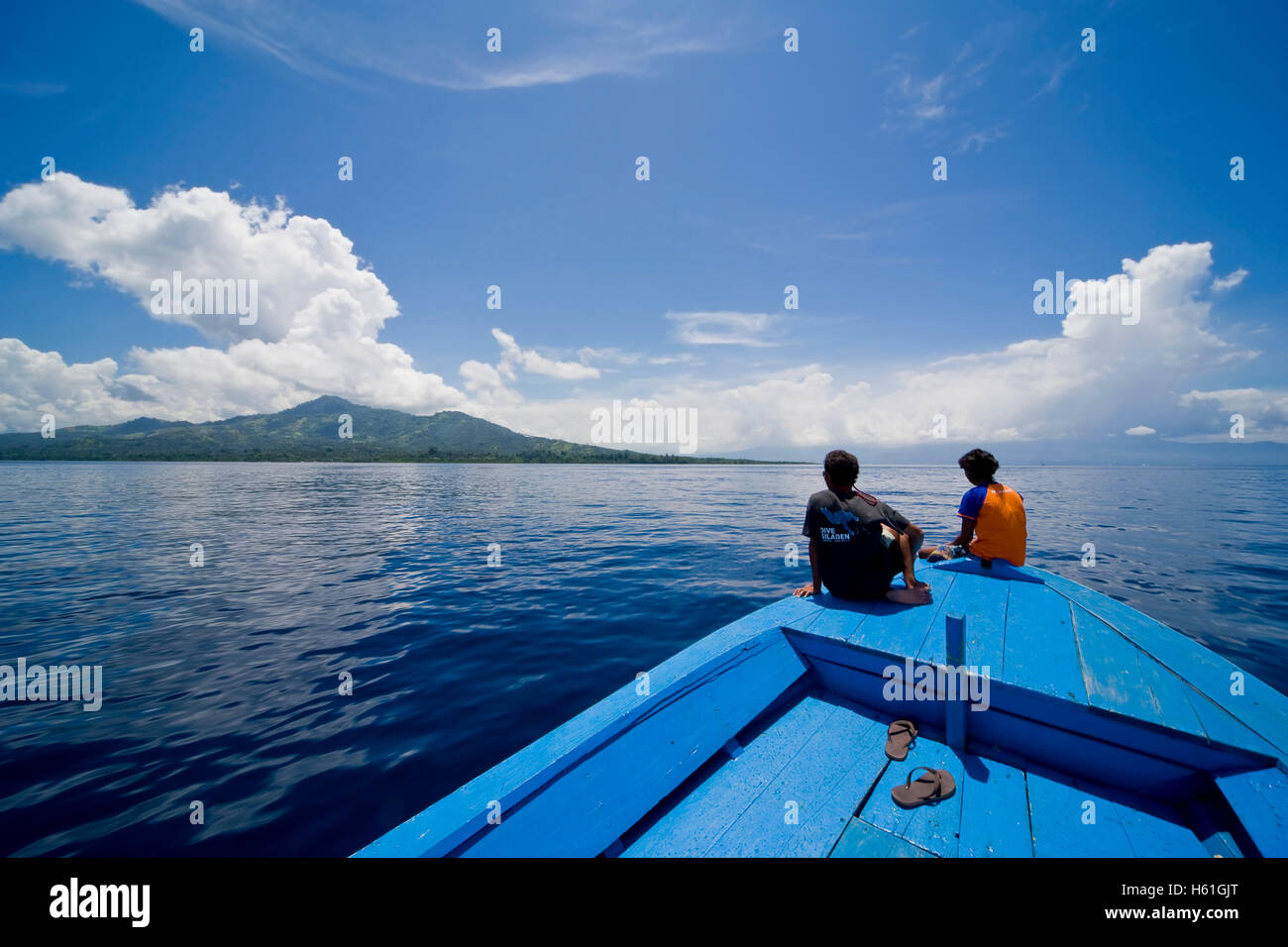 Young couple sitting at the bow of a wooden boat, Siladen island, Sulawesi, Indonesia, Southeast Asia Stock Photo