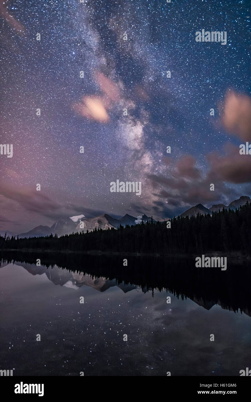 The summer Milky Way in portrait orientation over Herbert Lake and Mount Temple and peaks around Lake Louise, in Banff National Stock Photo
