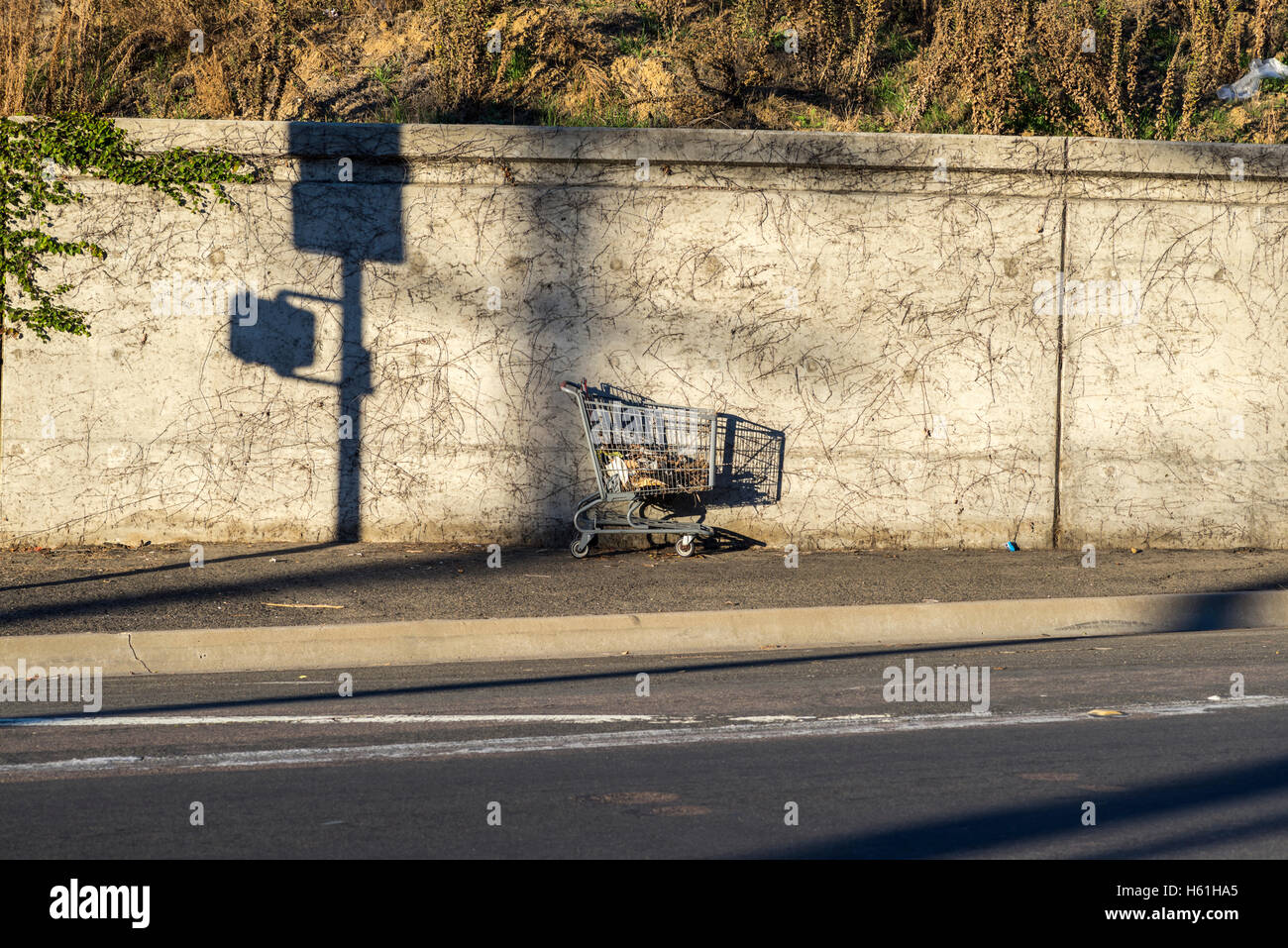 shopping cart against a concrete wall Stock Photo Alamy